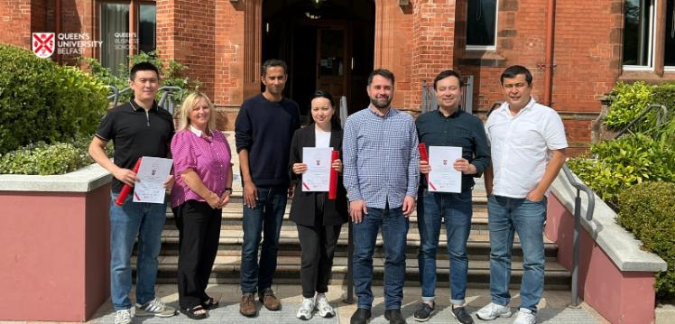 Seven people standing in front of Riddel Hall